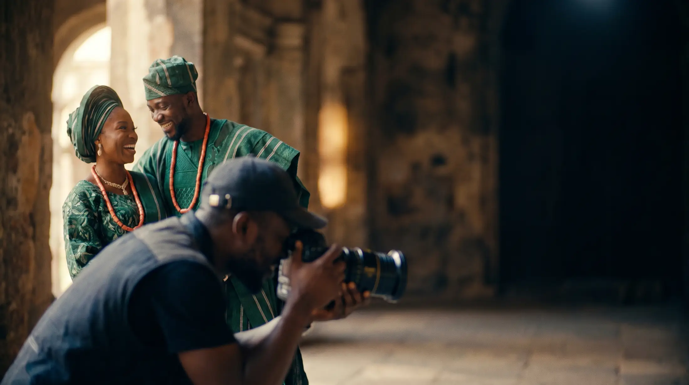 Photographer capturing a Nigerian couple in traditional attire at a dark elegant venue